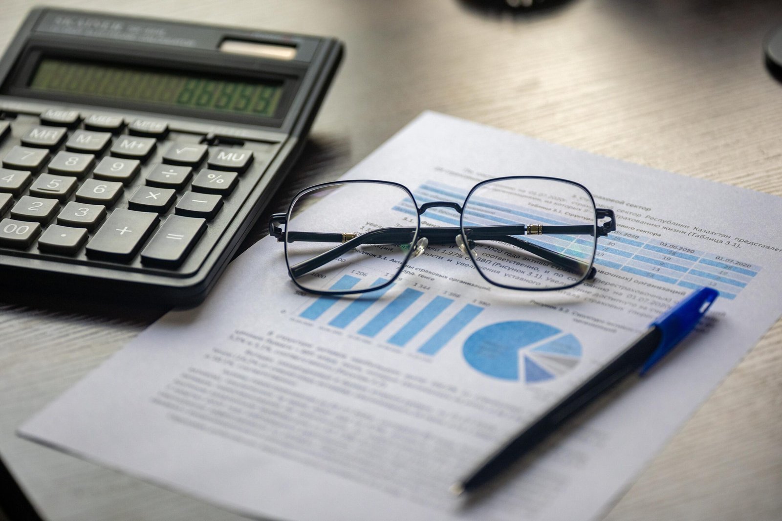 why-choose-us Financial document with a calculator, pen, and glasses symbolizing data analysis.